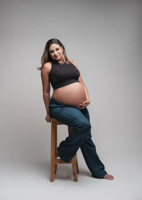 gestante com calça jeans 
toop preto 
inspiração para ensaio de gestante '