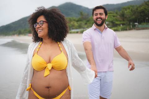 gestante correndo na praia com pai'