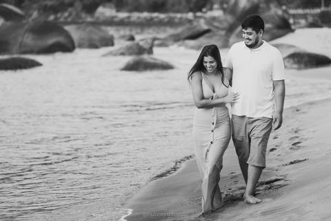 casal caminhando na praia'