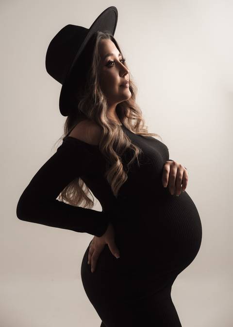 GESTANTE COM VESTIDO PRETO E CHAPÉU'