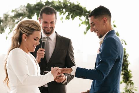 noiva colocando as alianças no noivo '