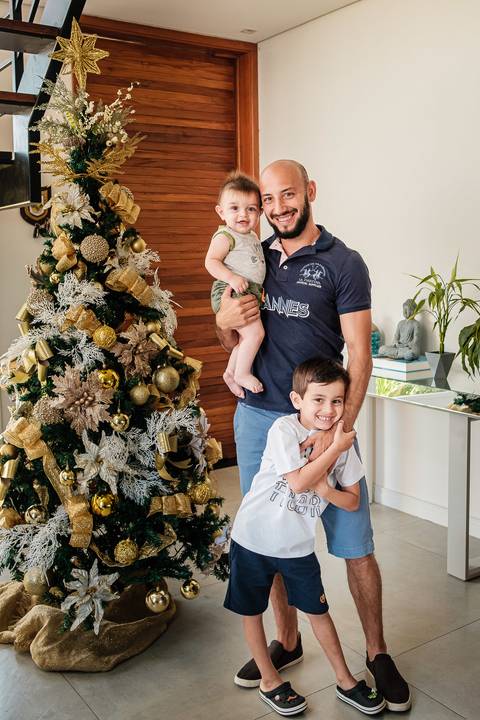 pai e filhos na árvore de natal'