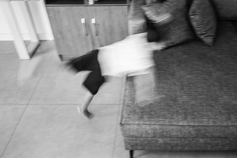 criança voando no sofá'
