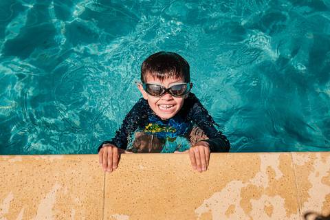 criança na piscina'