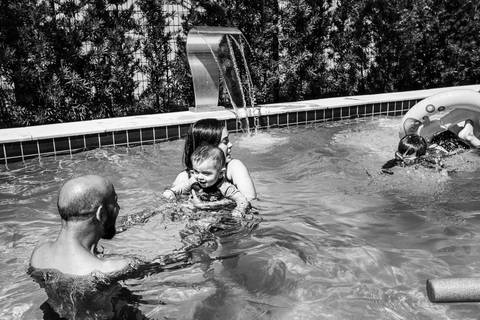 família brincando na piscina'