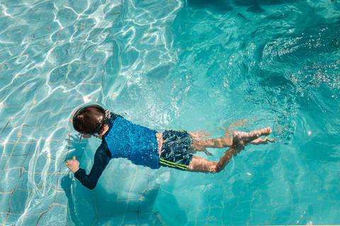 filho mergulhando na piscina'