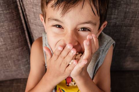 criança comendo pipoca '