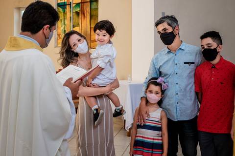 padre fazendo o batismo para a família'