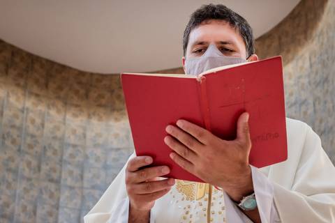 padre proferindo batismo'