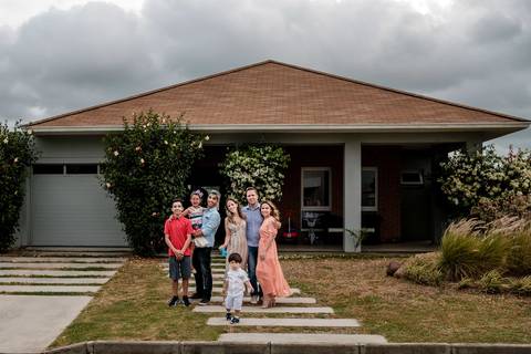 família posa em frente a casa nova'