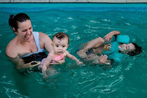 mãe e filhos na piscina'