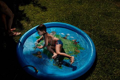 criança na piscina de plástico'