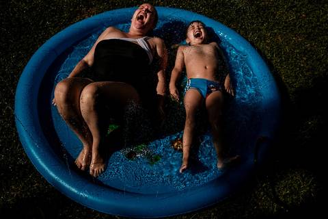 mãe e filho na piscina de plástico'