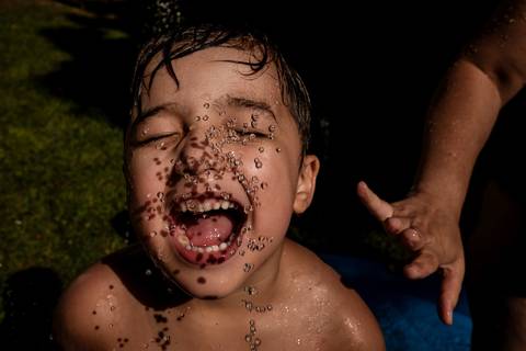 criança brincando na água'