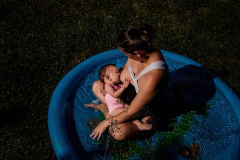 mãe amamentando na piscina'