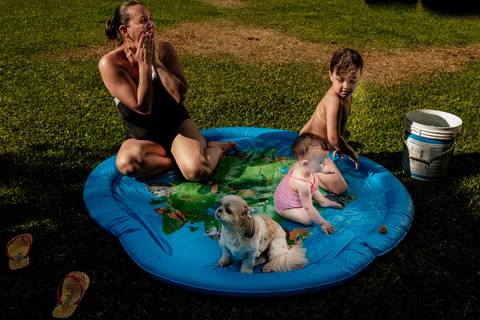 mãe filhos e cachorro na piscina'
