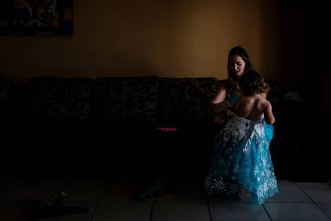 mulher vestindo menina com roupa de princesa'