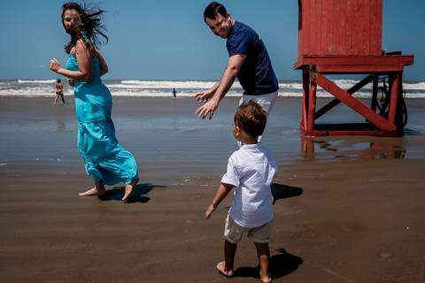 família correndo na beira da praia '