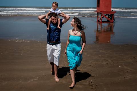 família caminhando na beira da praia'