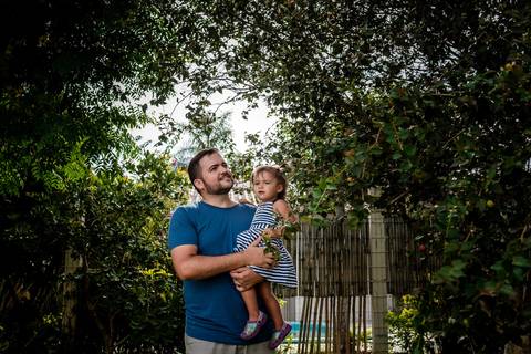 pai e filha tirando pitanga da árvore'