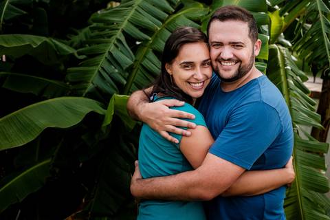 casal abraçado e sorrindo para a câmera'