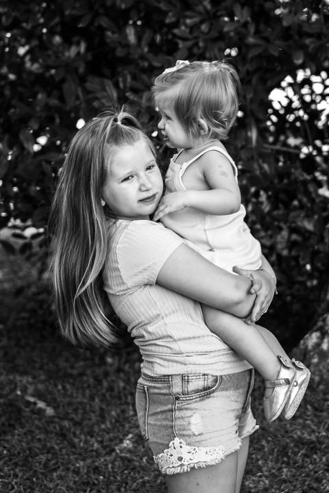 irmã maior com a irmã menor no colo'