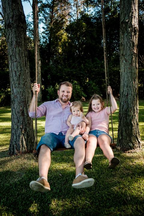 pai e filhas brincando'