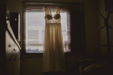 vestido de noiva pendurado na contra luz'