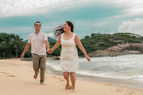 casal correndo na praia no ensaio pré wedding'