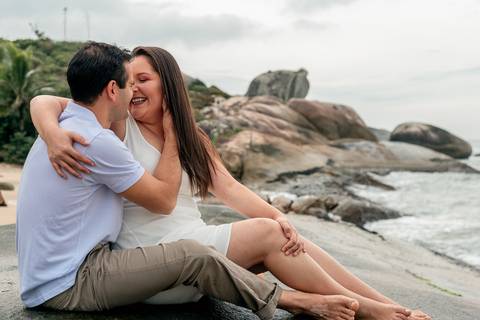 casal se acariciando nas pedras na praia'