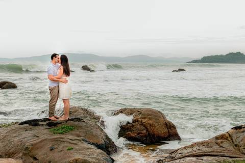 casal se beijando nas pedras na praia'