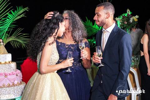 mãe e filha na cerimonia de 15 anos na hora do beijo e seu irmão de terno azul'