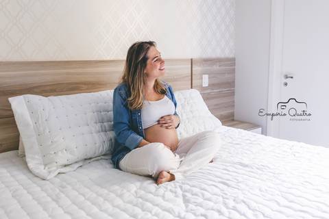 ensaio gestante mãe na cama segurando a barriga'