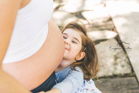 ensaio gestante filha beijando a barriga ao ar livre'