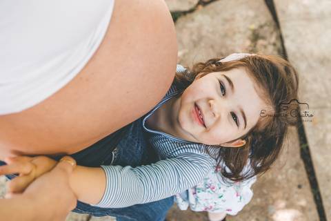 ensaio gestante filha abraçada com a barriga da mãe ao ar livre'