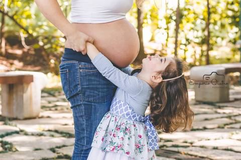 ensaio gestante filha e mãe abraçadas ao ar livre'