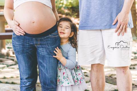 ensaio gestante família reunida mostrando a barriga ao ar livre'