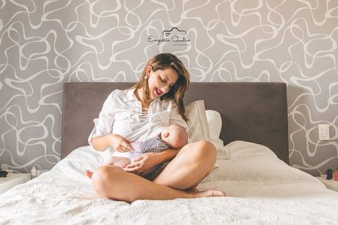 ensaio lifestyle mãe na cama amamentando o bebê'