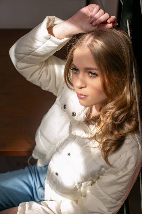 Book 15anos - ensaio 15ano menina loira com calça jeans, blusa preta de paetê e jaqueta branca sentada em um escada luz natural do sol iluminando seu rosto. Fábio Martins fotografo'
