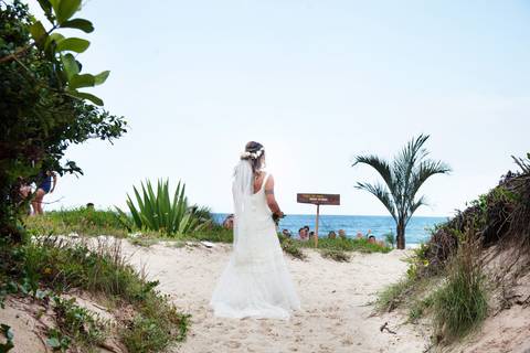 noiva-chegando-ao-altar-na-beira-da-praia-convidados-vestimenta-festa-casamento-na-beira-da-praia-do-rosa-sal-e-mar-making-of-noivo-se-arrumando-para-o-casamento-na-praia-do-rosa-em-santa-catarina-fotografia-making-of-noiva-na-praia-do-rosa-casamento-na-b'