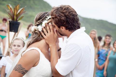 noiva-beijando-noivo-casal-se-beijando-na-praia-noiva-chegando-ao-altar-na-beira-da-praia-convidados-vestimenta-festa-casamento-na-beira-da-praia-do-rosa-sal-e-mar-making-of-noivo-se-arrumando-para-o-casamento-na-praia-do-rosa-em-santa-catarina-fotografia'