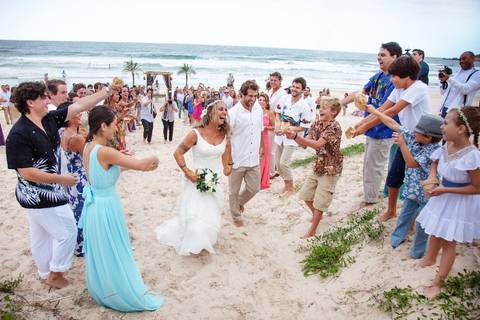 noiva-beijando-noivo-casal-se-beijando-na-praia-noiva-chegando-ao-altar-na-beira-da-praia-convidados-vestimenta-festa-casamento-na-beira-da-praia-do-rosa-sal-e-mar-making-of-noivo-se-arrumando-para-o-casamento-na-praia-do-rosa-em-santa-catarina-fotografia'