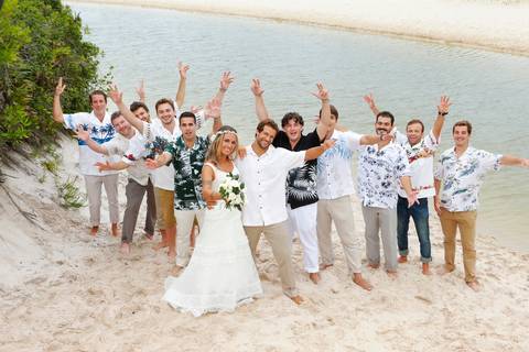 noiva-beijando-noivo-casal-se-beijando-na-praia-noiva-chegando-ao-altar-na-beira-da-praia-convidados-vestimenta-festa-casamento-na-beira-da-praia-do-rosa-sal-e-mar-making-of-noivo-se-arrumando-para-o-casamento-na-praia-do-rosa-em-santa-catarina-fotografia'