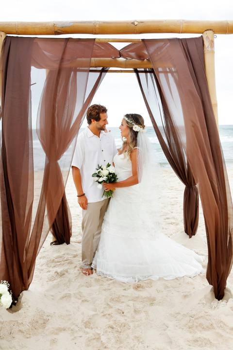 noiva-beijando-noivo-casal-se-beijando-na-praia-noiva-chegando-ao-altar-na-beira-da-praia-convidados-vestimenta-festa-casamento-na-beira-da-praia-do-rosa-sal-e-mar-making-of-noivo-se-arrumando-para-o-casamento-na-praia-do-rosa-em-santa-catarina-fotografia'