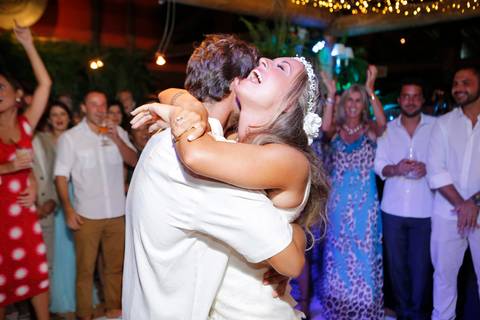 noiva-beijando-noivo-casal-se-beijando-na-praia-noiva-chegando-ao-altar-na-beira-da-praia-convidados-vestimenta-festa-casamento-na-beira-da-praia-do-rosa-sal-e-mar-making-of-noivo-se-arrumando-para-o-casamento-na-praia-do-rosa-em-santa-catarina-fotografia'