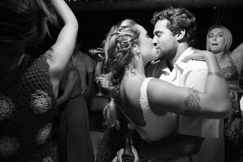 noiva-beijando-noivo-casal-se-beijando-na-praia-noiva-chegando-ao-altar-na-beira-da-praia-convidados-vestimenta-festa-casamento-na-beira-da-praia-do-rosa-sal-e-mar-making-of-noivo-se-arrumando-para-o-casamento-na-praia-do-rosa-em-santa-catarina-fotografia'