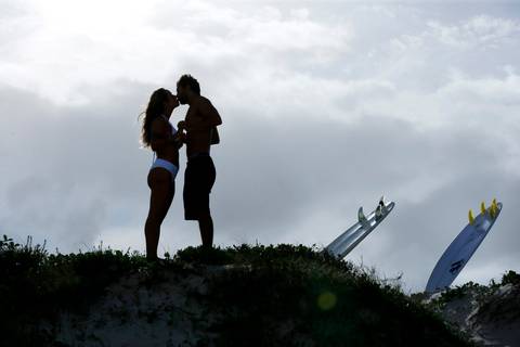noiva-beijando-noivo-casal-se-beijando-na-praia-noiva-chegando-ao-altar-na-beira-da-praia-convidados-vestimenta-festa-casamento-na-beira-da-praia-do-rosa-sal-e-mar-making-of-noivo-se-arrumando-para-o-casamento-na-praia-do-rosa-em-santa-catarina-fotografia'