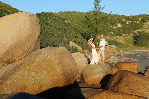 FOTOGRAFIA-NA-PRAIA-DE-GAROPABA-E-PRAIA-DO-ROSA-PRÉ-WEDDING-Fotos-de-noivas-na-praia-do-rosa-ao-nascer-do-sol-casal-segurando-as-maos-nas-pedras-da-praia-de-santa-catarina-fotografia-praia-de-sc-casamento-noivo-noiva-casal-pedras-beira-praia-garopaba-sc'