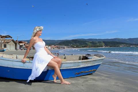 fotos noiva no barco com mar ao fundo com linda cor azul. Noiva com coroa de flores naturais com lindo mar azul ao fundo.'