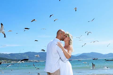 fotos casal na praia de Garopaba santa catarina  com gaivotas ao fundo.'
